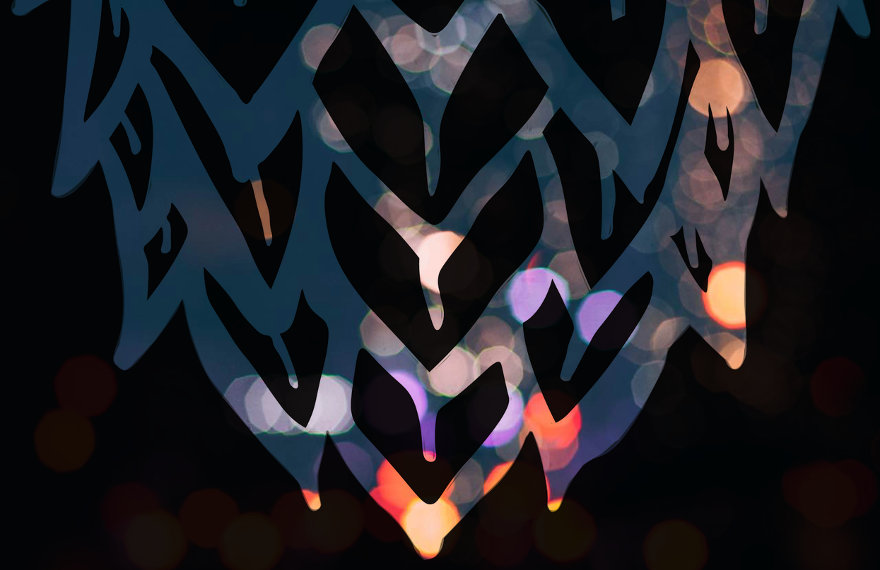 A close up of a paper cut out of a heart with lights in the background.