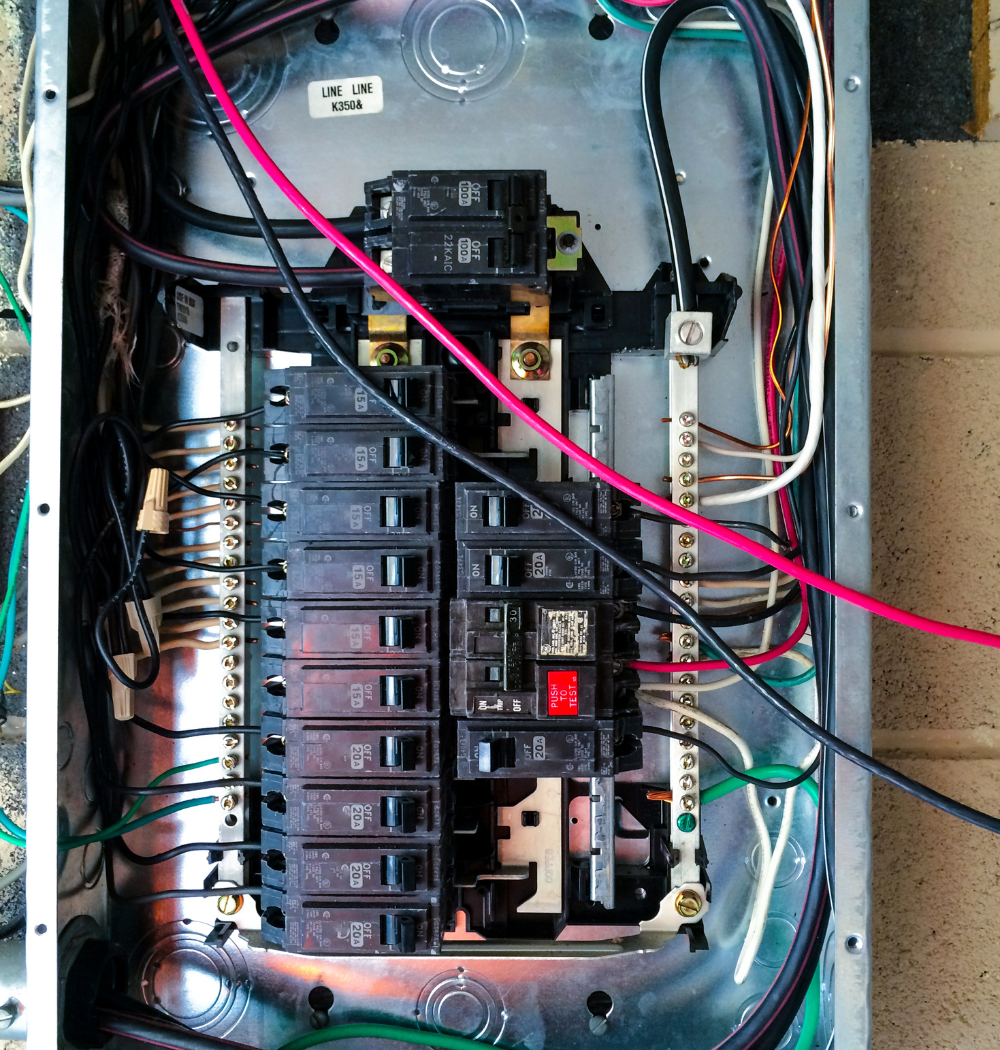 Electrical breaker box with wires and circuit breakers.