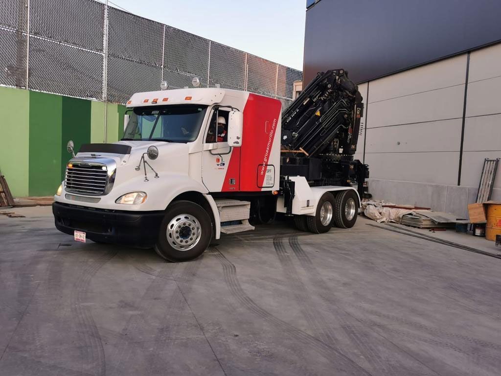 Un camión blanco y rojo está estacionado en un estacionamiento.