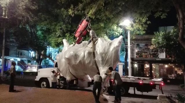 Una gran estatua de un caballo está siendo cargada en una grúa.