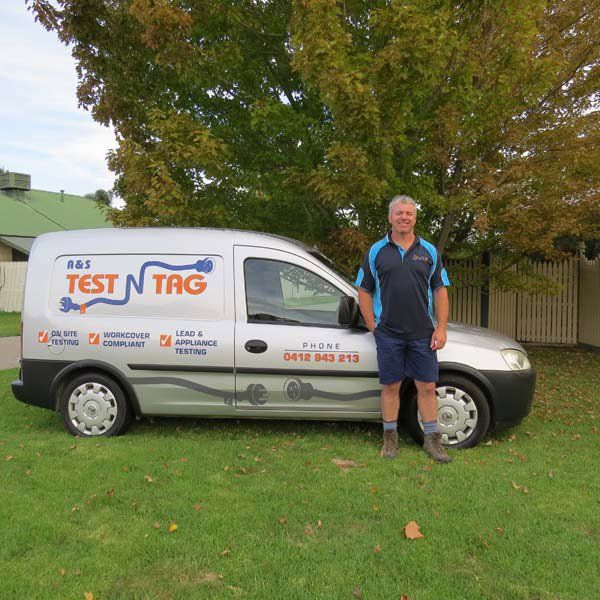 man next to test and tag van