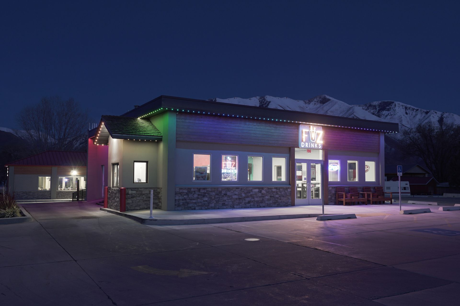 A building with a lot of windows is lit up at night.