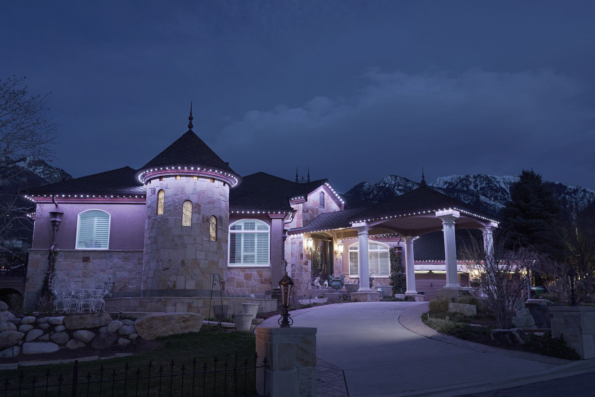 A large house is lit up with rainbow lights at night.