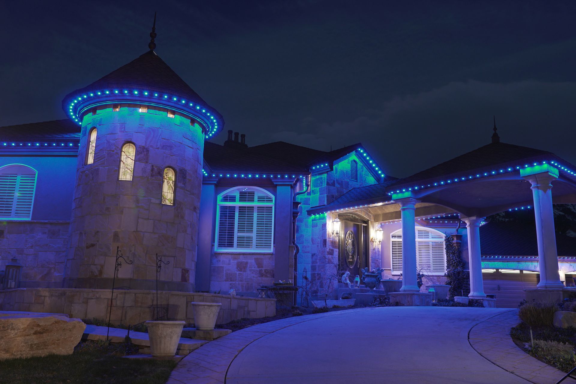 A large house is lit up with blue lights at night.