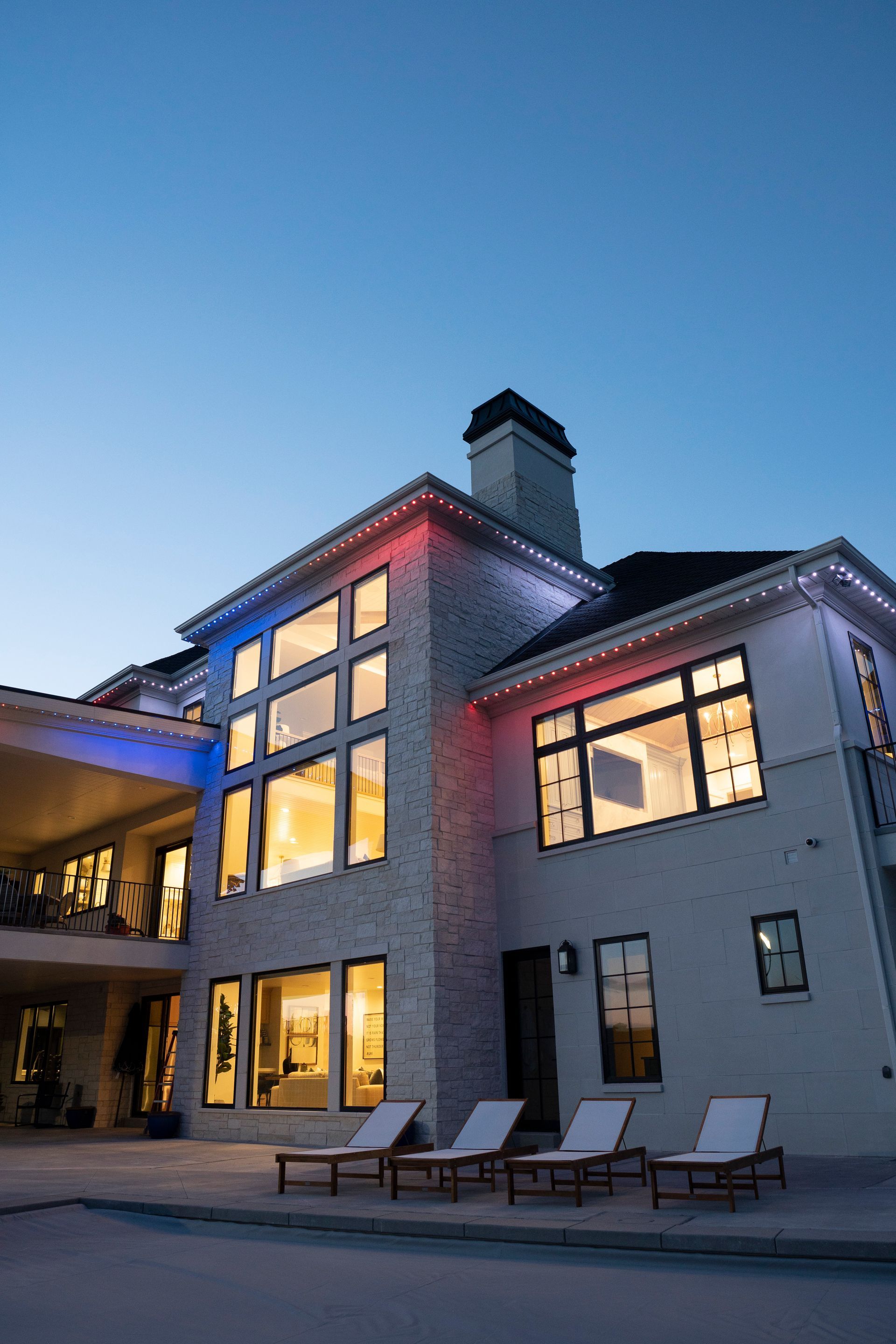 A large white house with a lot of windows is lit up at night.