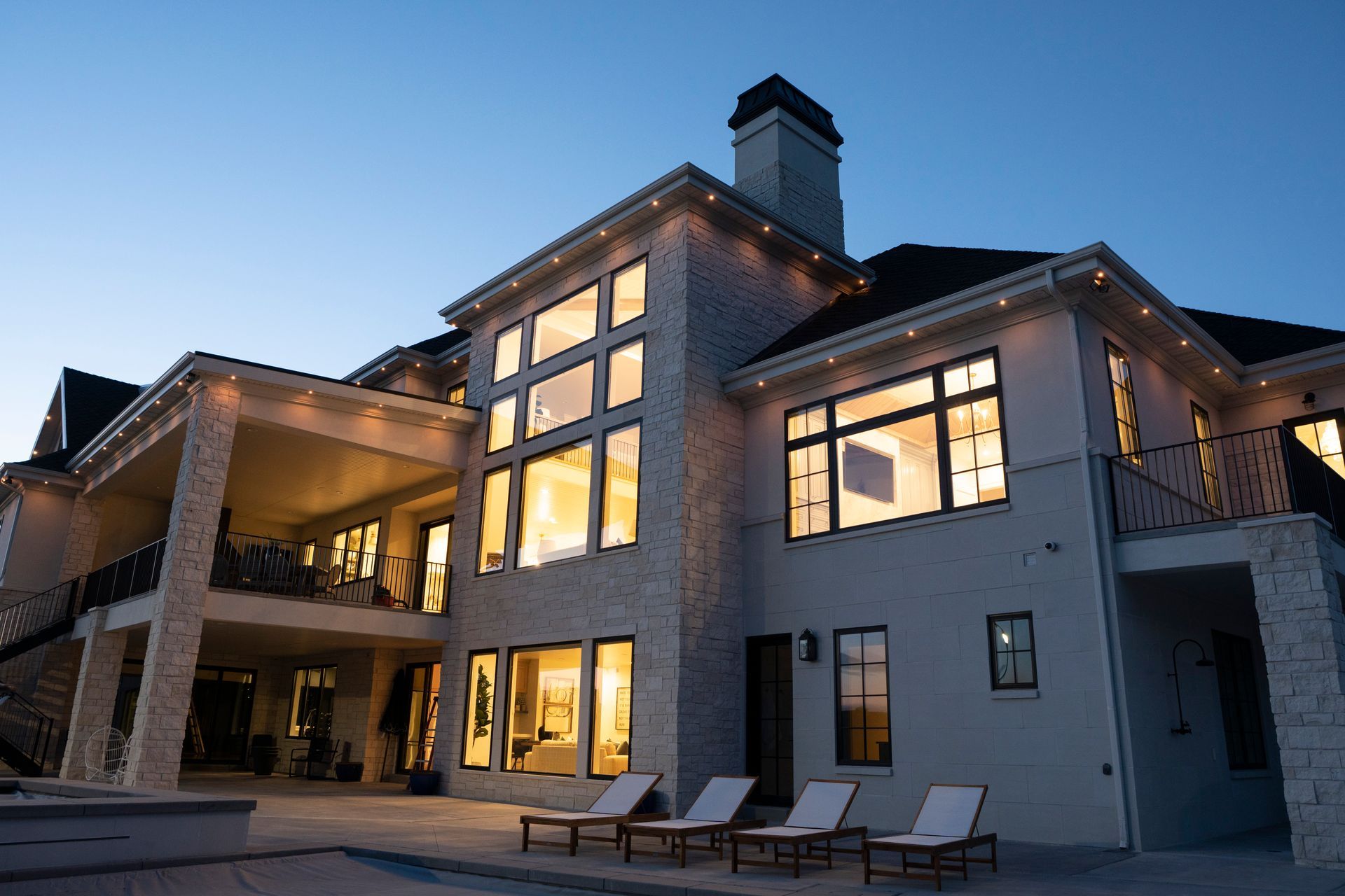 A large house with a lot of windows is lit up at night.