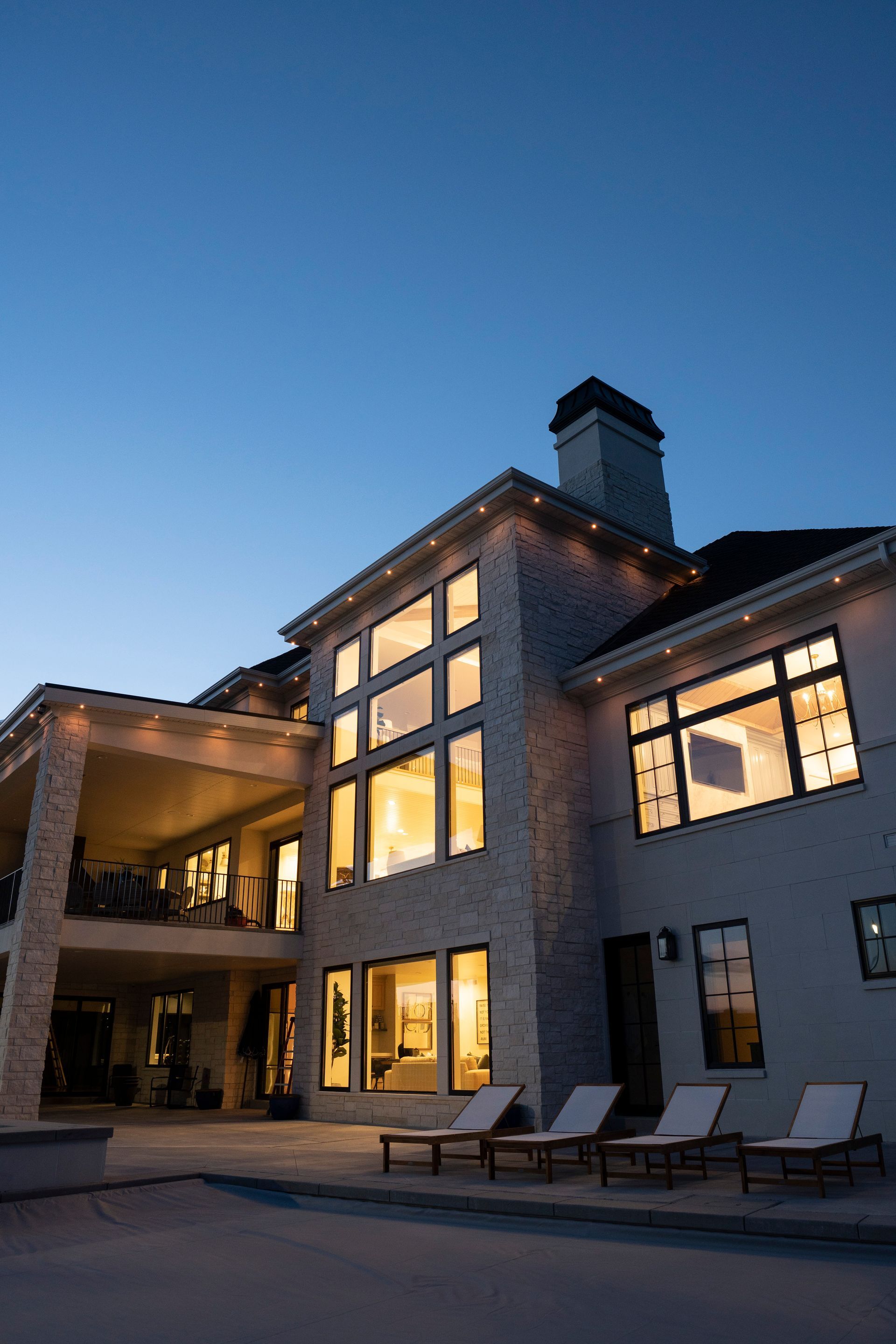 A large house with a lot of windows is lit up at night.