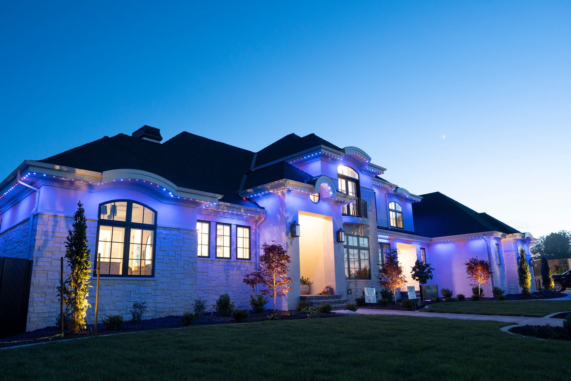 A large house is lit up with blue lights at night