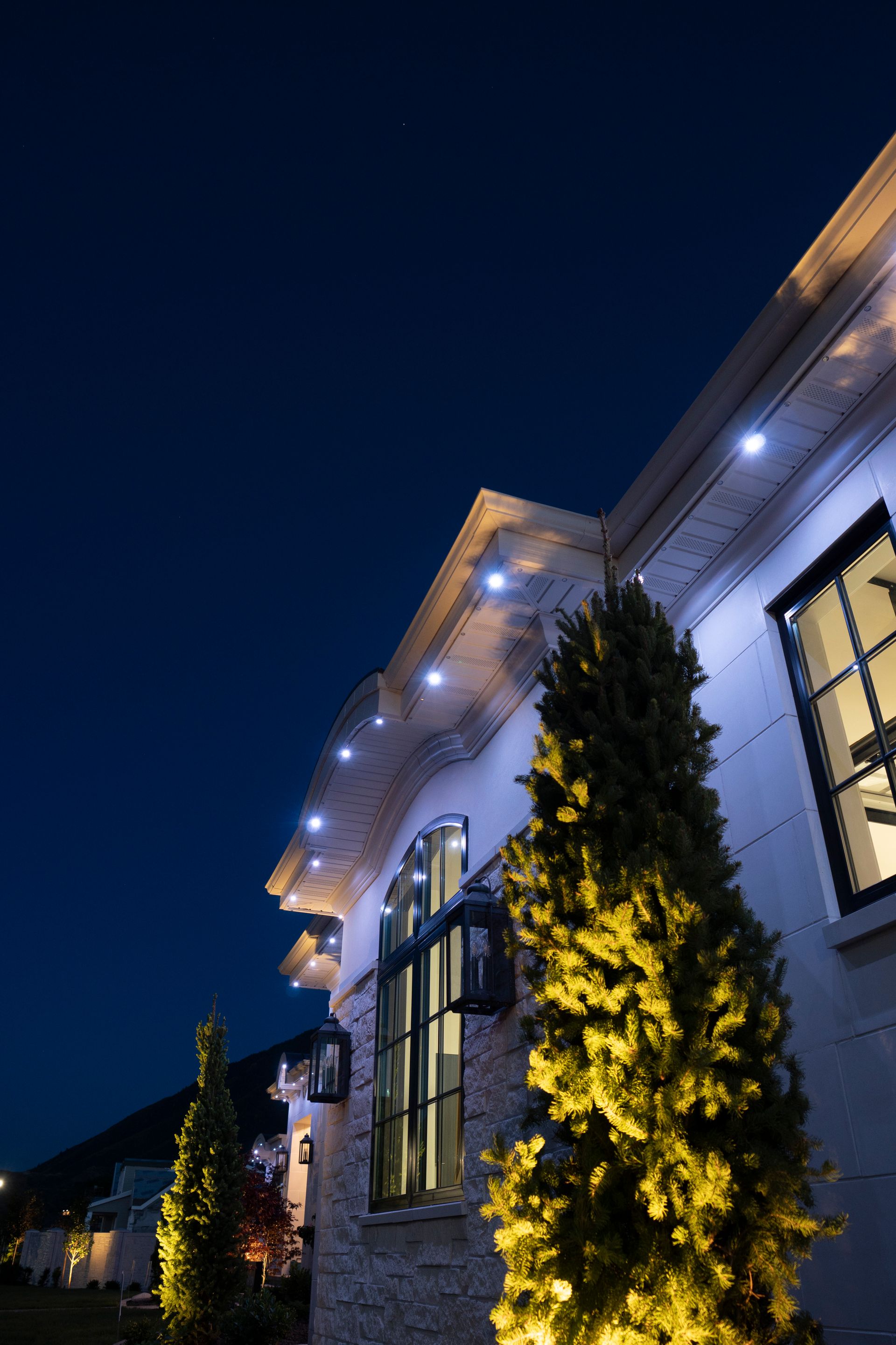 A house with christmas lights on the side of it at night.