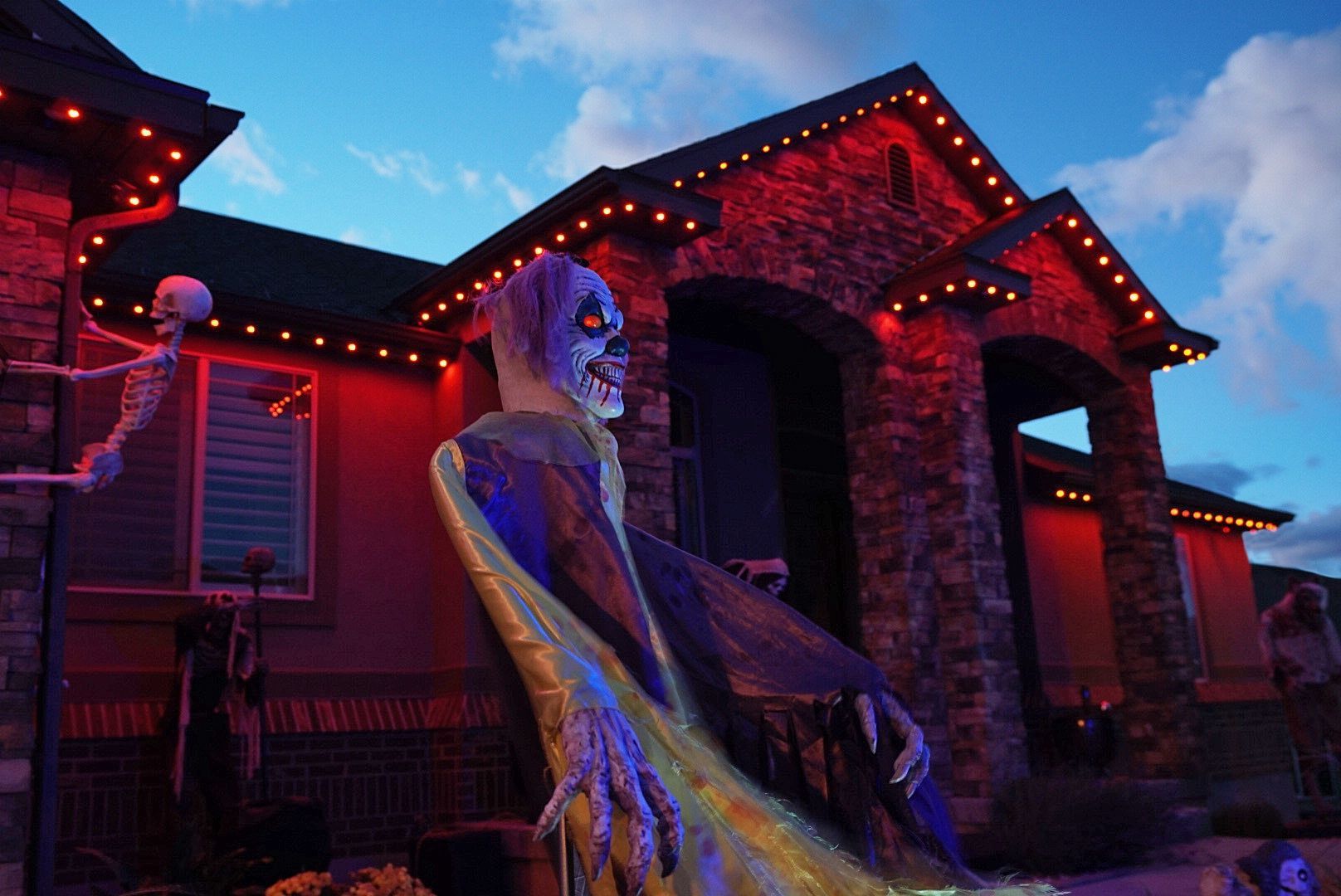 A house decorated for halloween with a skeleton and a bat