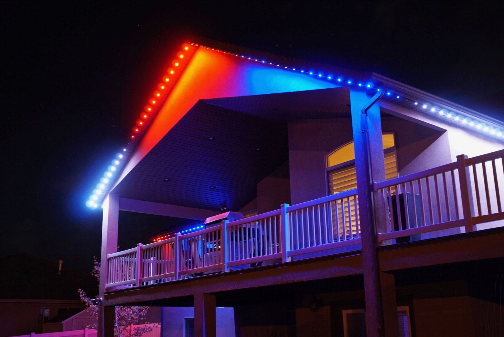 The roof of a house is lit up with red , white and blue lights.