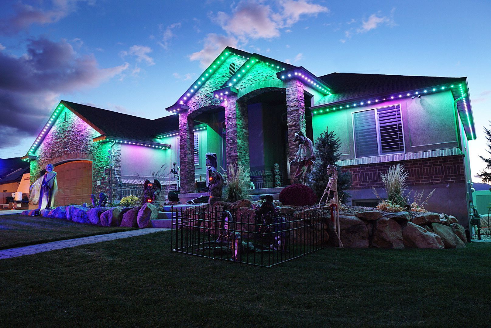 A house is decorated for halloween with purple and green lights.
