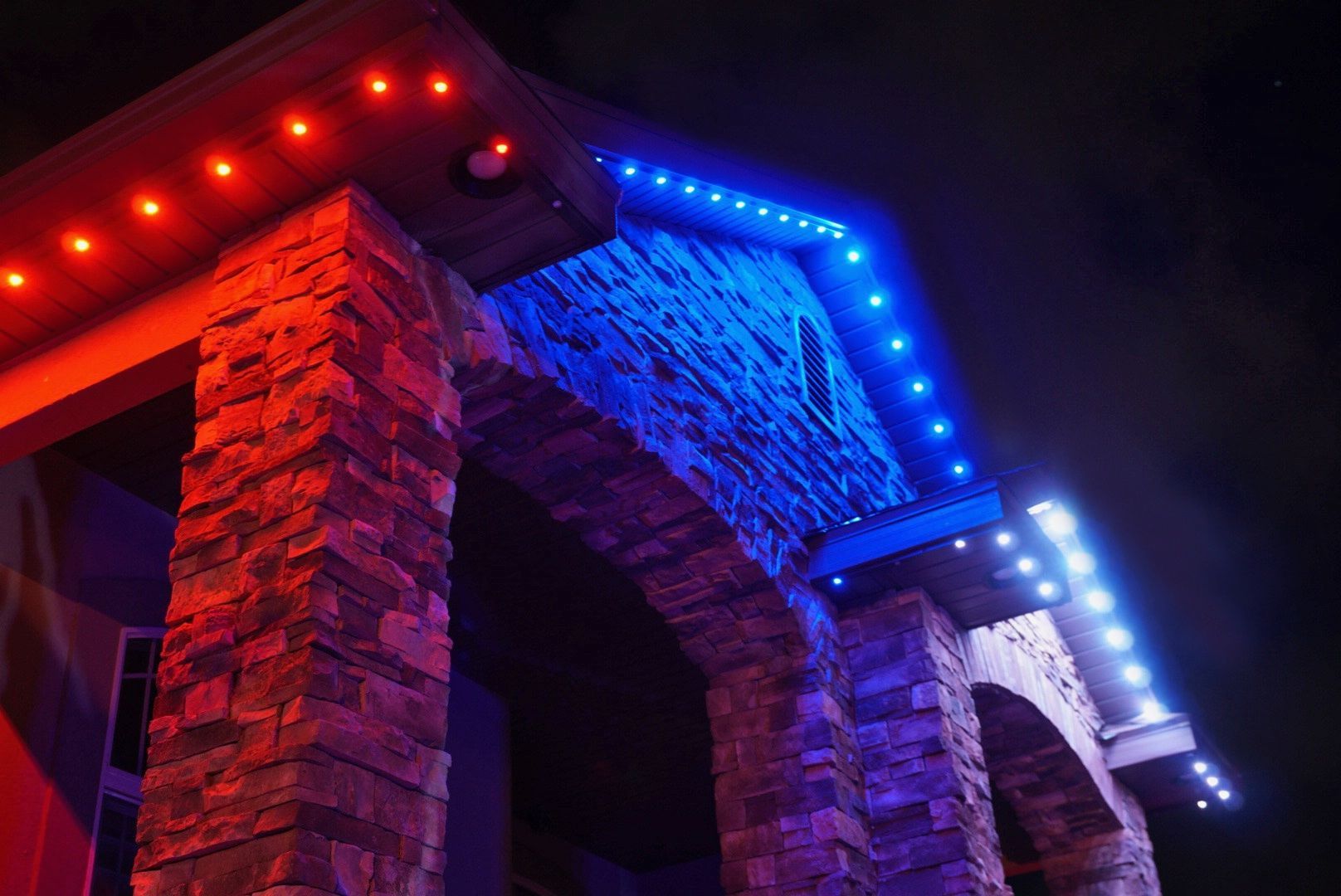 A building with red and blue lights on it at night.