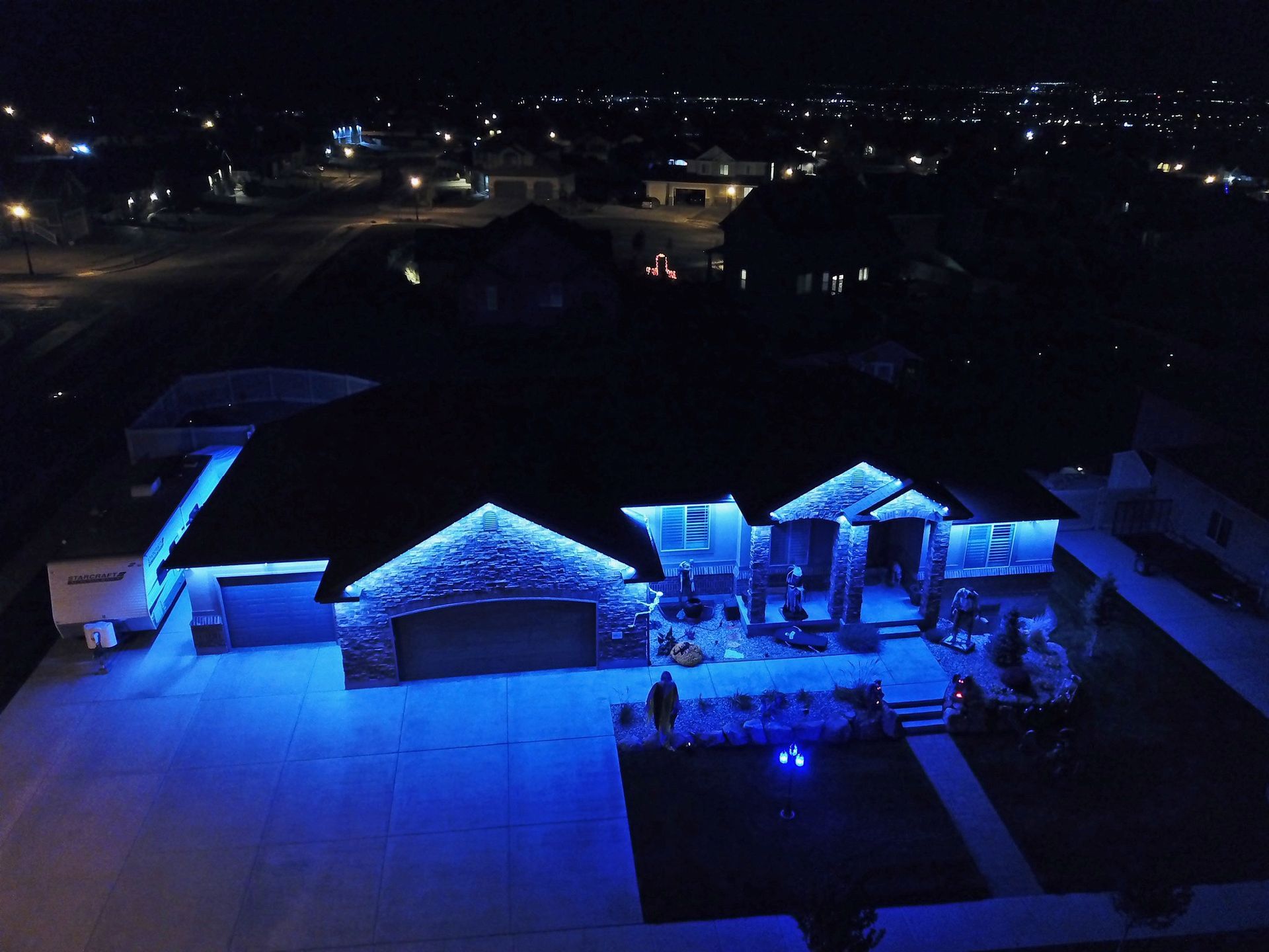 An aerial view of a house lit up with blue lights at night