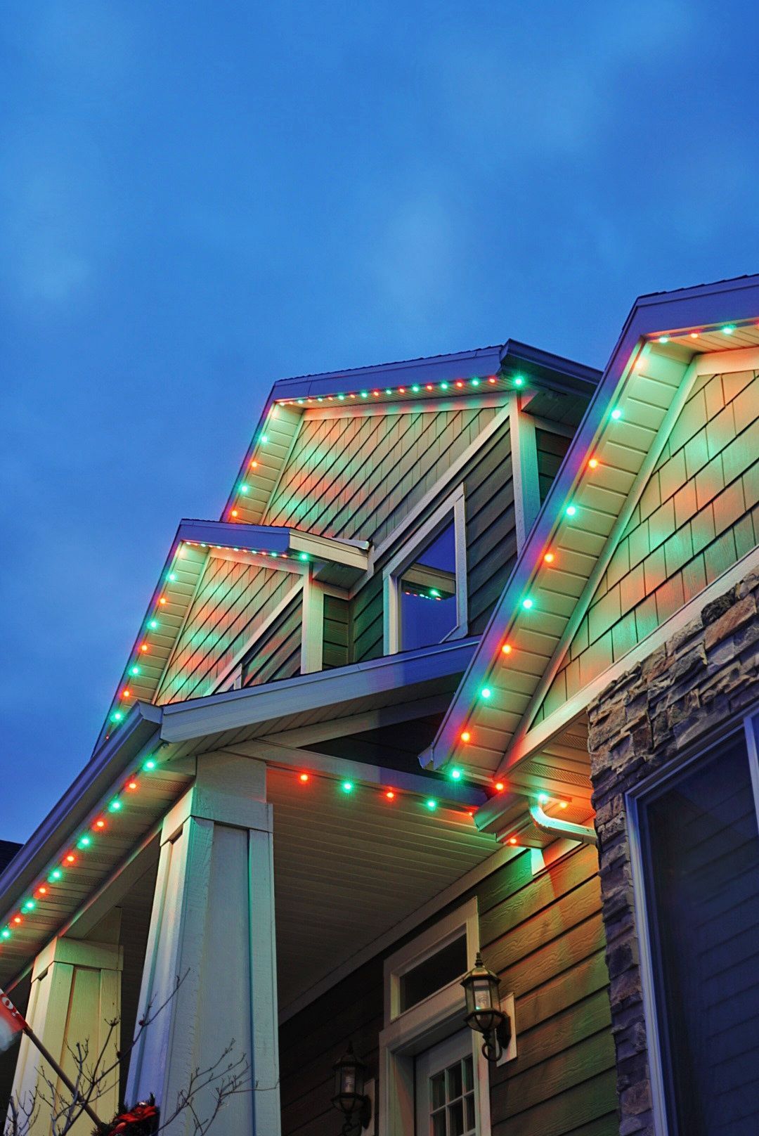 The roof of a house is decorated with christmas lights.
