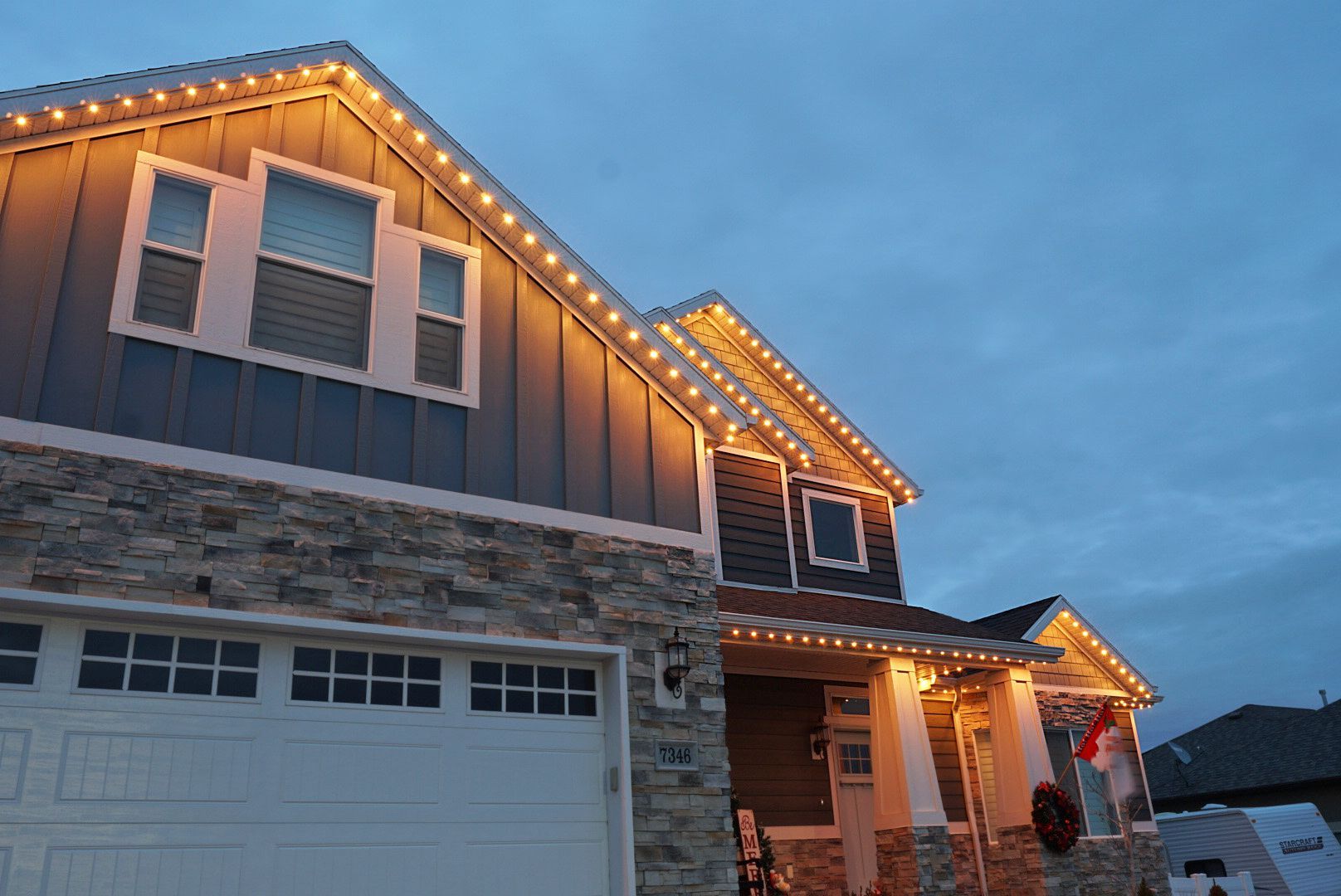 A house with christmas lights on it is lit up at night.