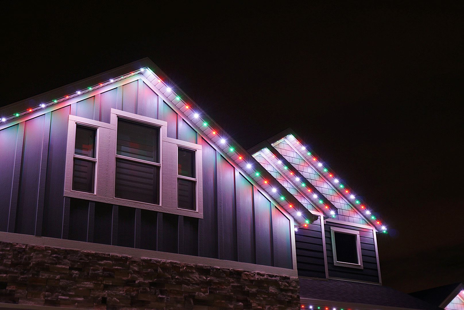 A house with christmas lights on it at night