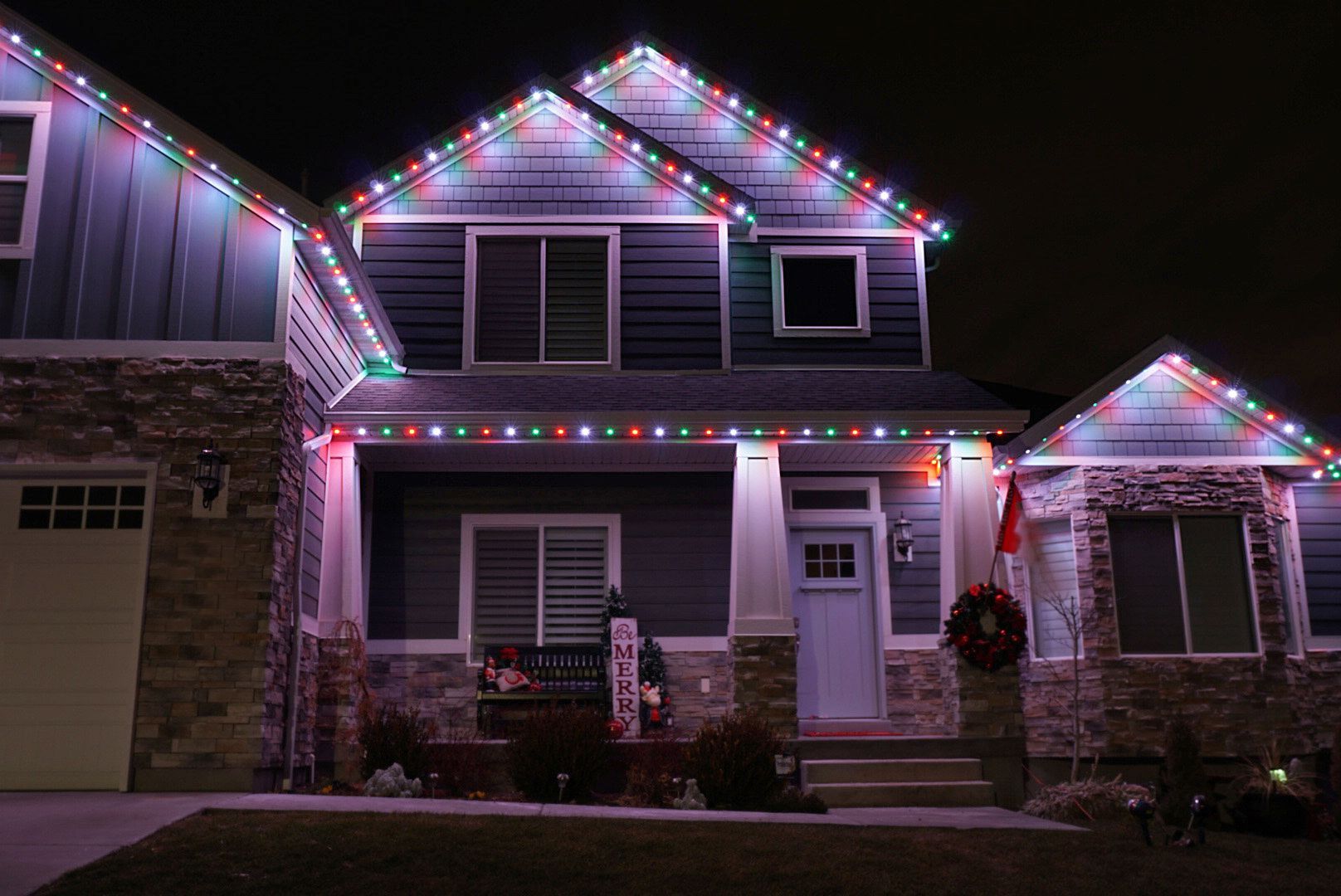 A house is decorated with christmas lights at night.