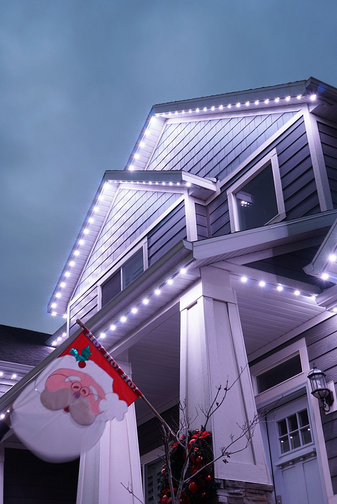 A house with christmas lights and a santa flag on the porch.
