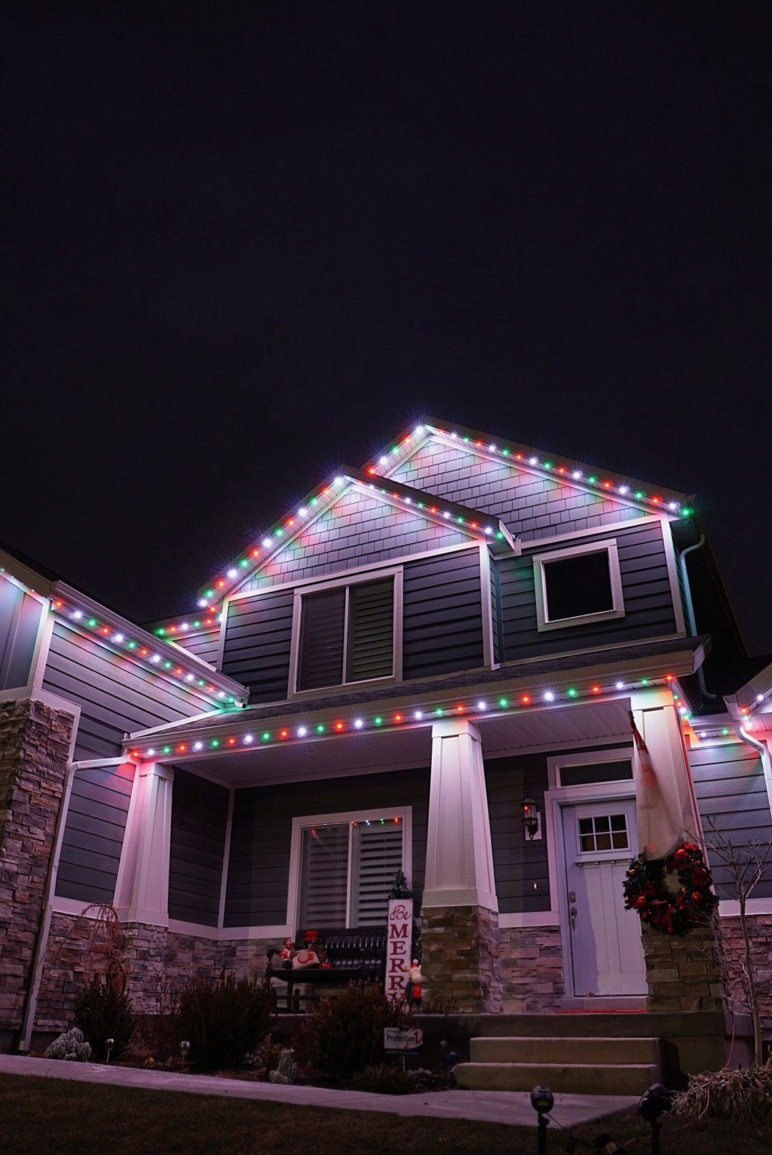 A house is decorated with christmas lights at night.
