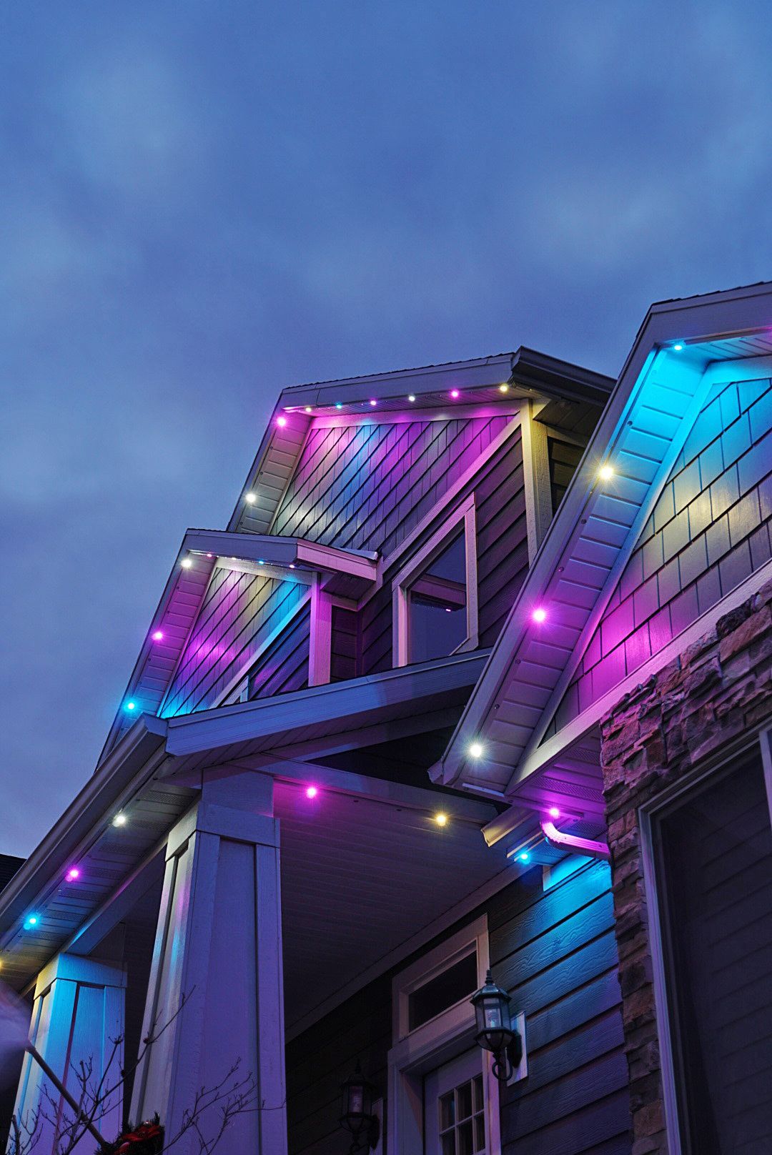 A house is decorated with purple and blue christmas lights.