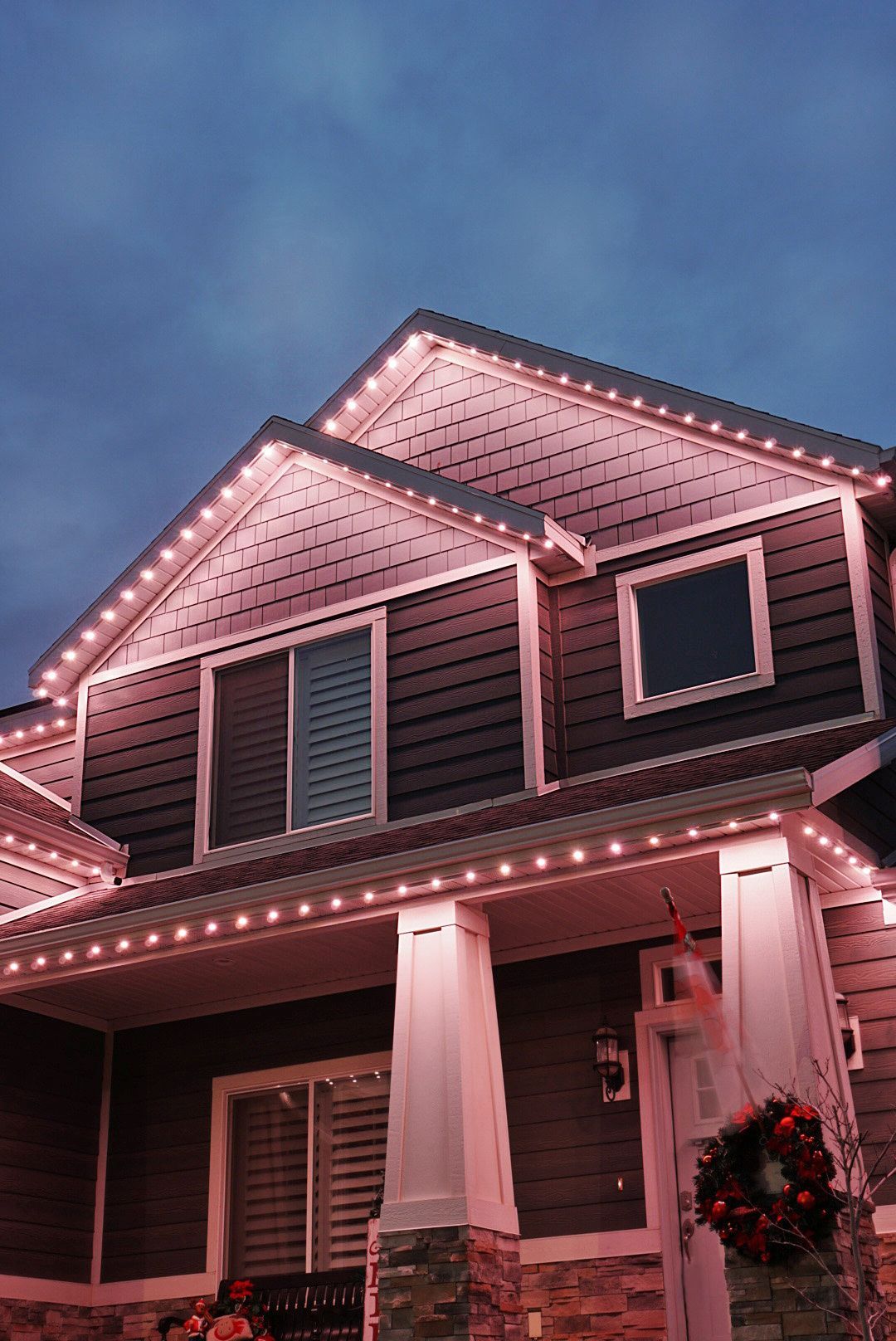 A house is decorated with christmas lights and a wreath.