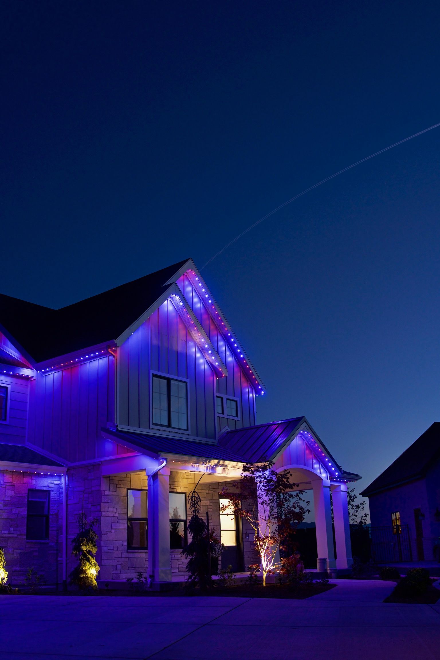A house is decorated with purple christmas lights at night.