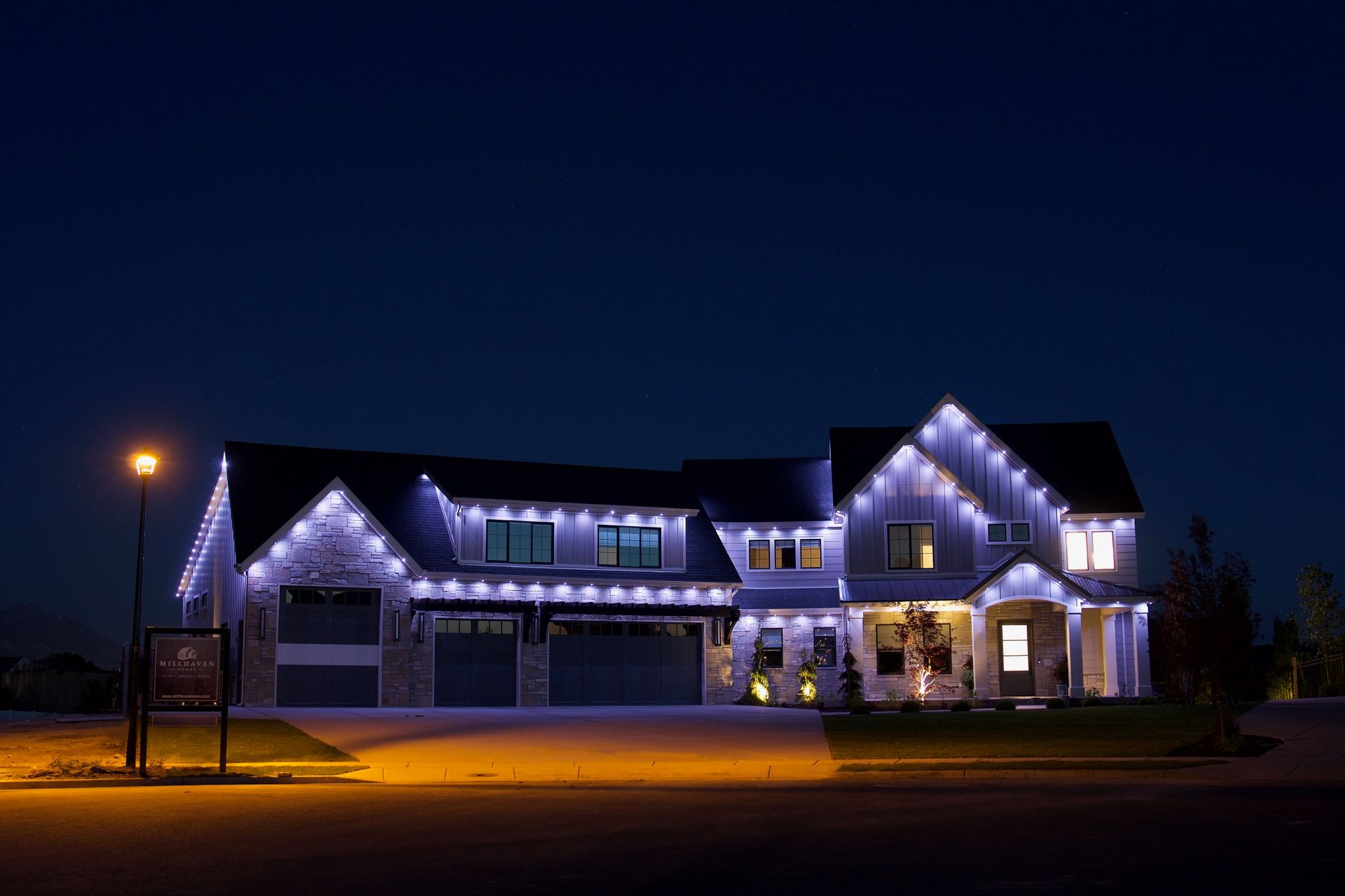 A large house is lit up with christmas lights at night.