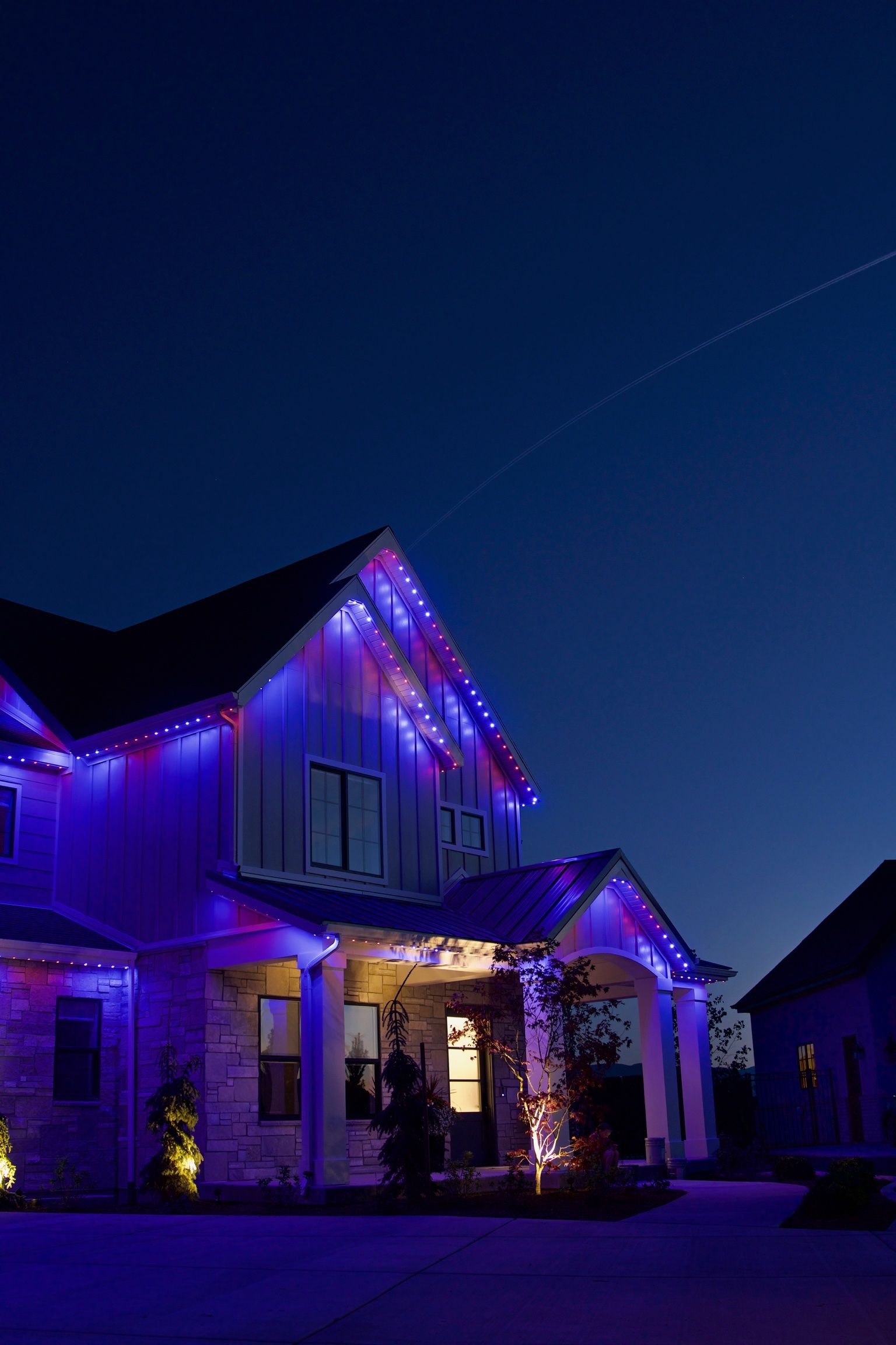 A house is decorated with purple christmas lights at night.