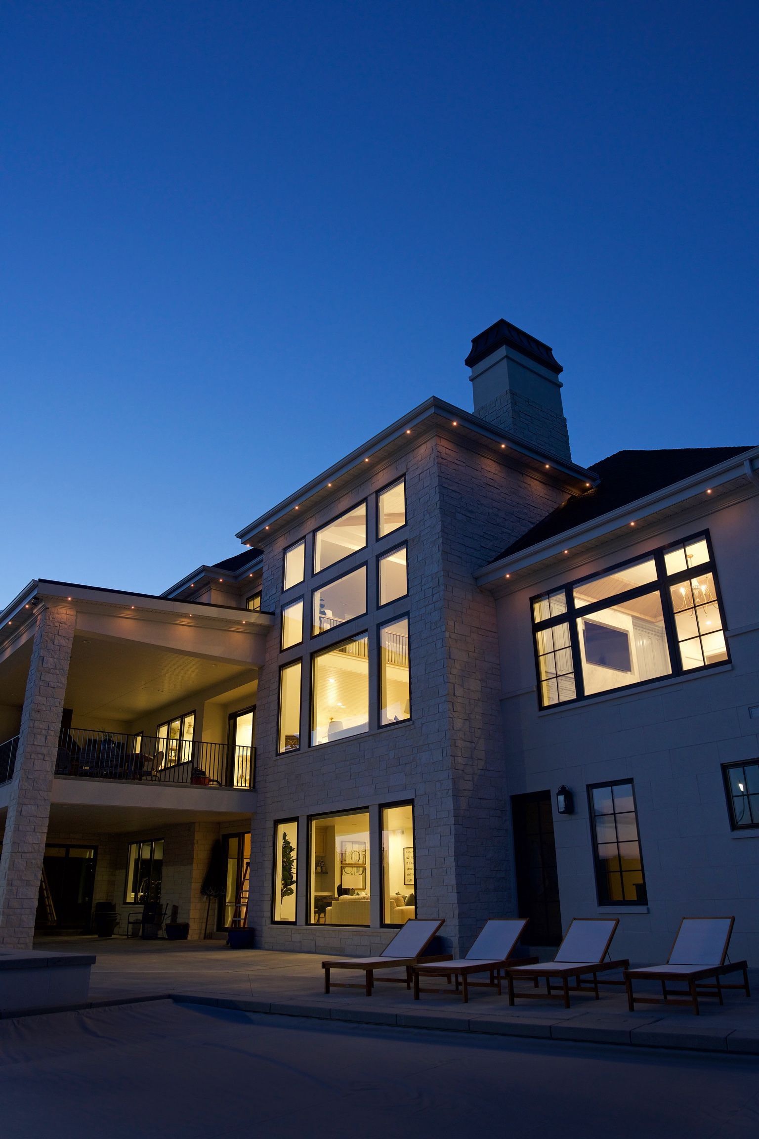 A large house with lots of windows is lit up at night