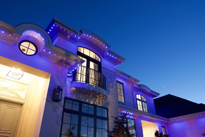 A large white house with blue lights on it at night