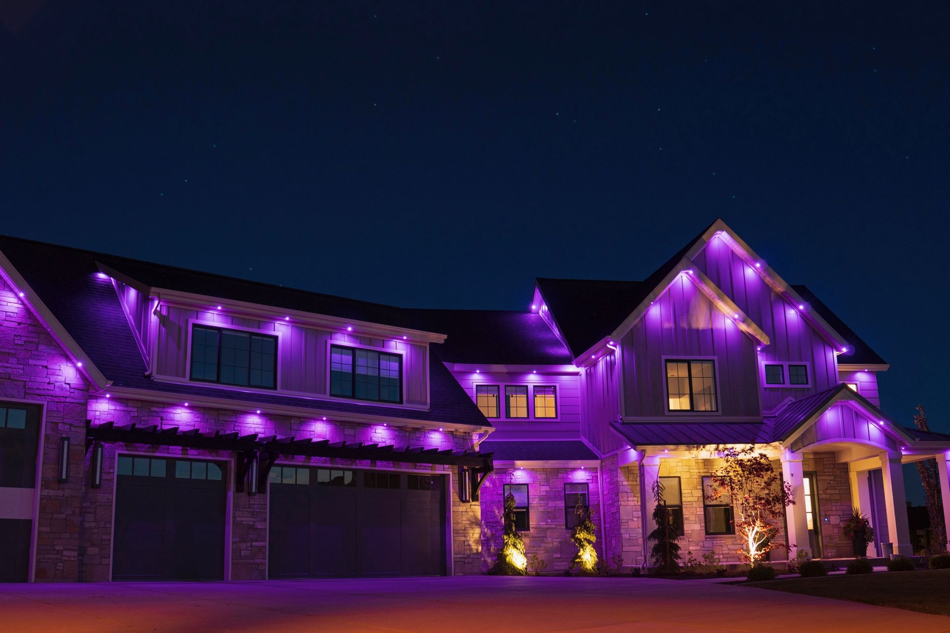 A large house is lit up with purple lights at night.