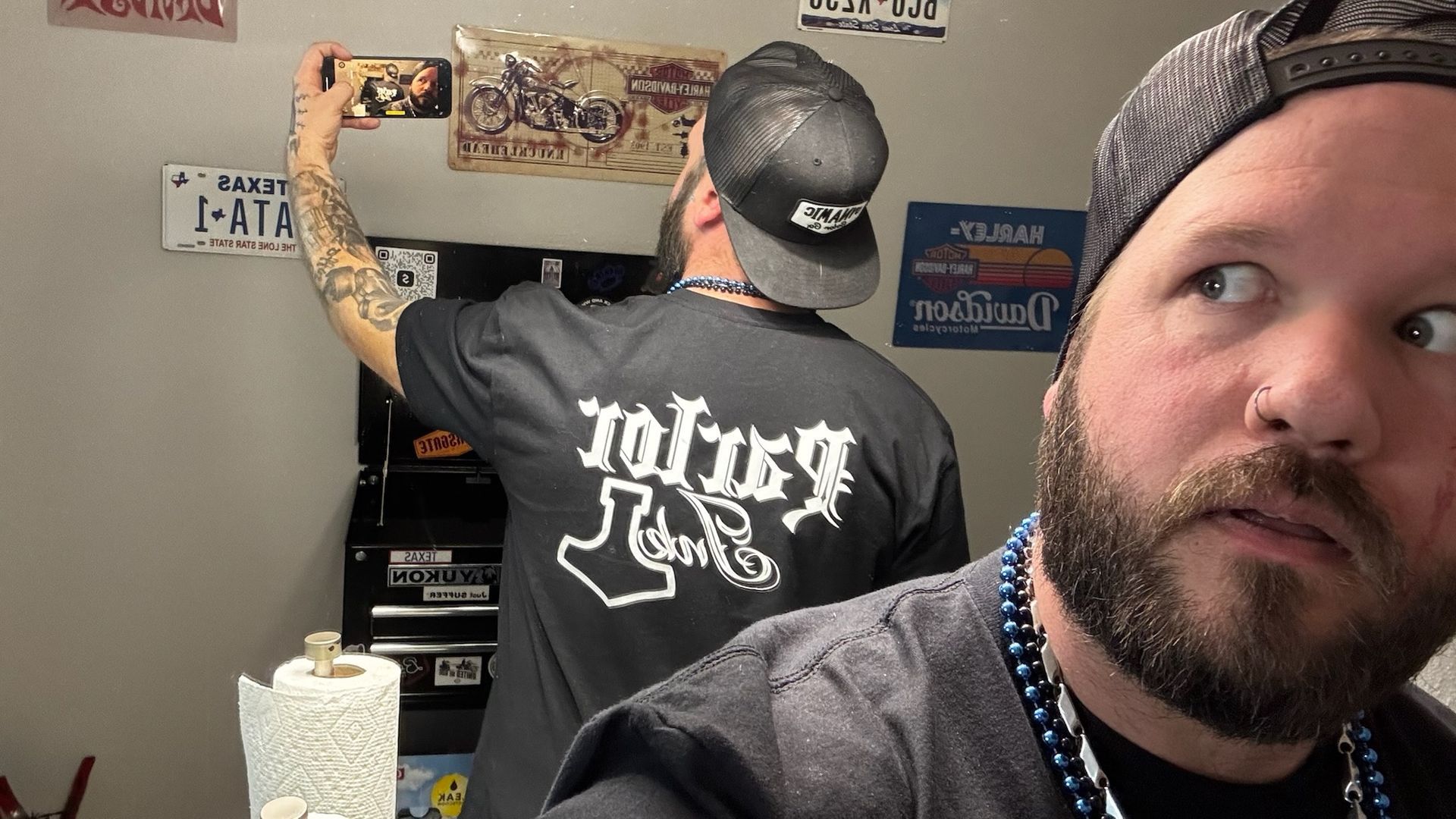 A man with a beard is wearing a shirt that says ' tough ' on it