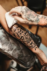 A person is getting a tattoo on their arm.