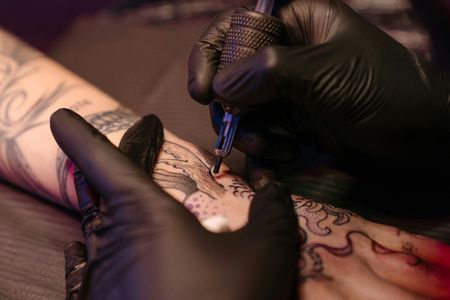 A person is getting a tattoo on their arm.