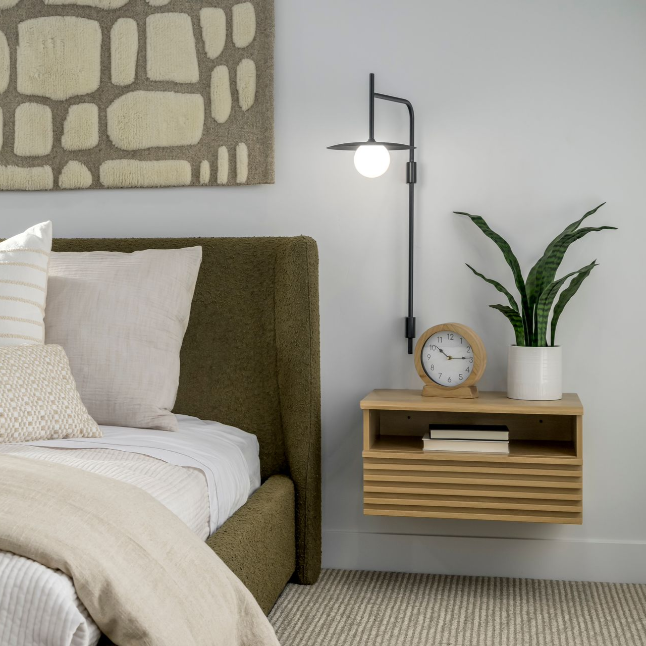 Modern kitchen with light wood cabinets, marble countertops, and island with bar stools.
