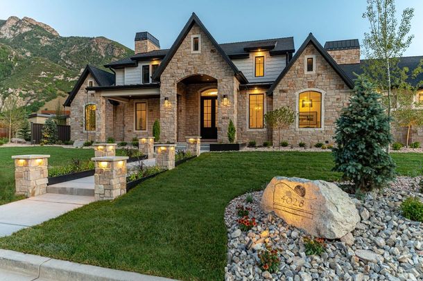 A large brick house with a large lawn in front of it.