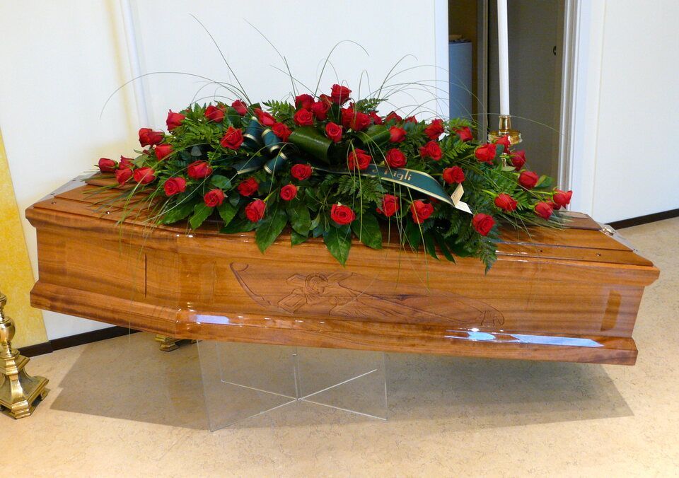 Rose rosse su cofano funebre