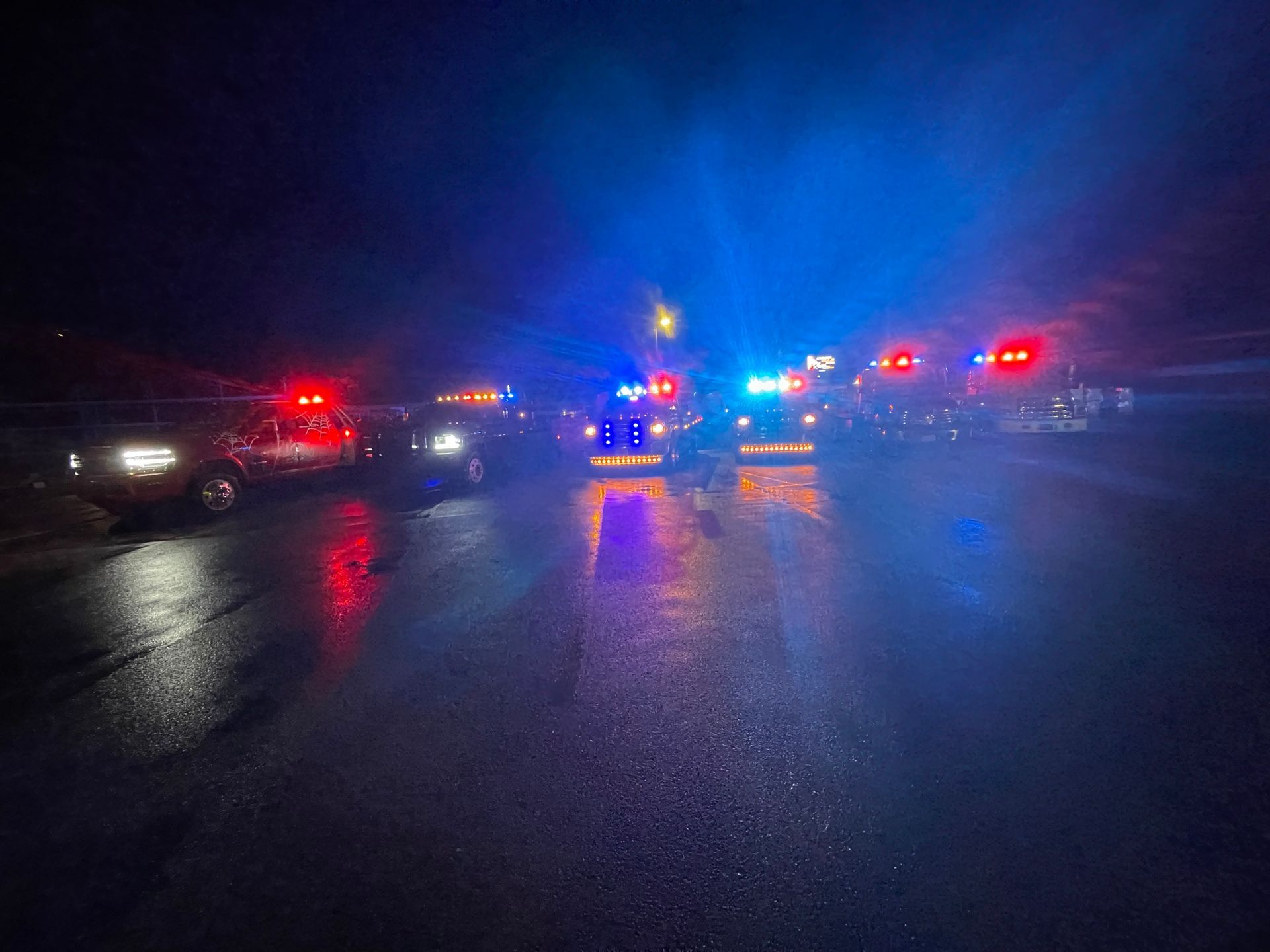 A blurry picture of a police car driving down a street at night.