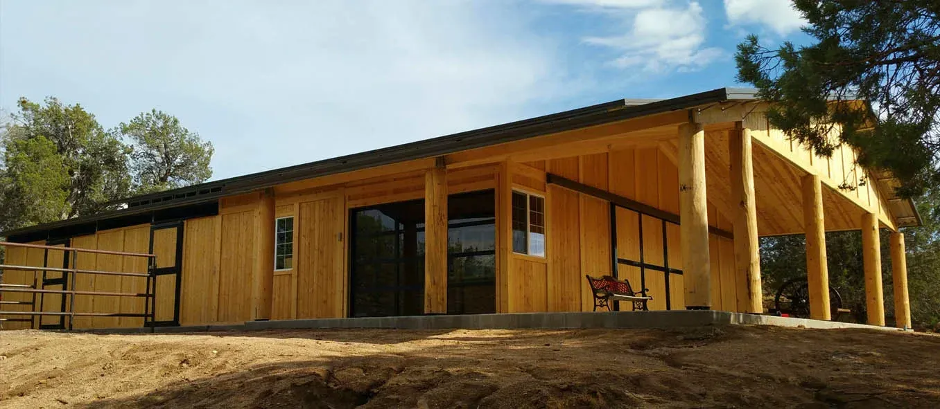 A large wooden house is sitting on top of a dirt hill.