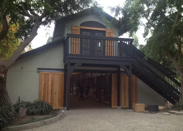 A house with a balcony and stairs leading up to it.