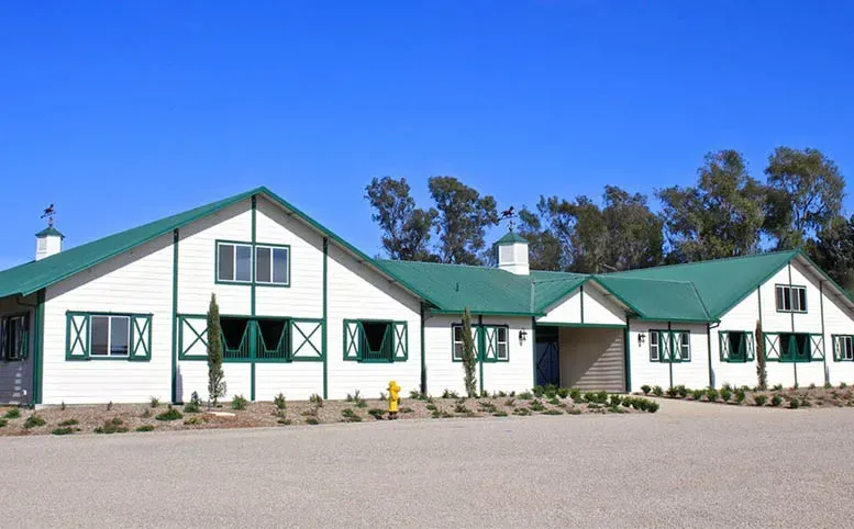 A large white building with a green roof