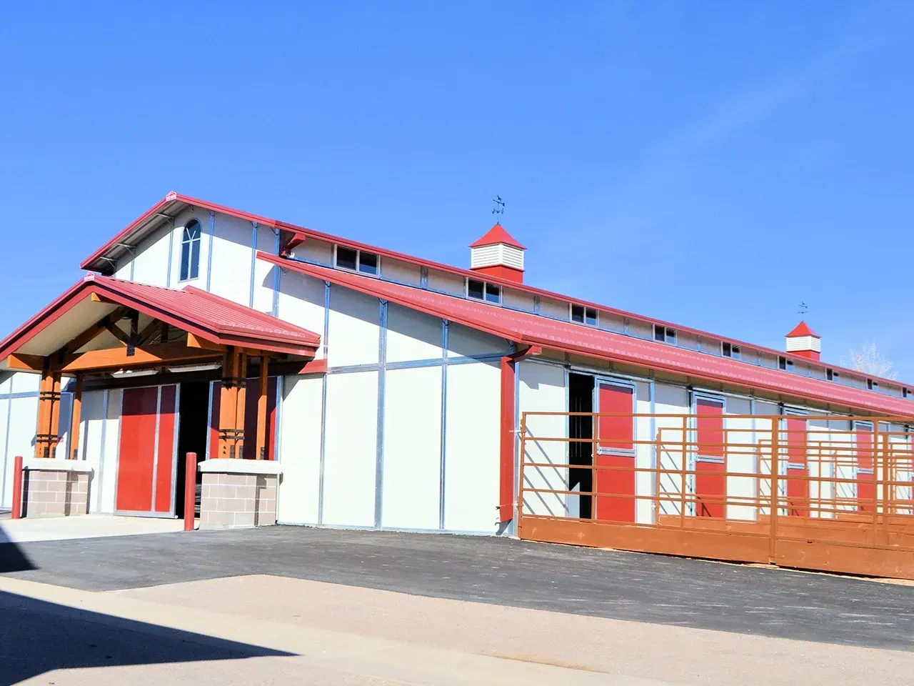 A white building with a red roof and red doors