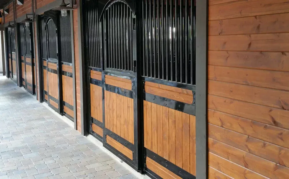 A row of wooden stable doors with black trim