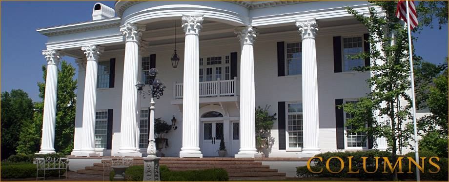 A large white house with columns and a flag in front of it