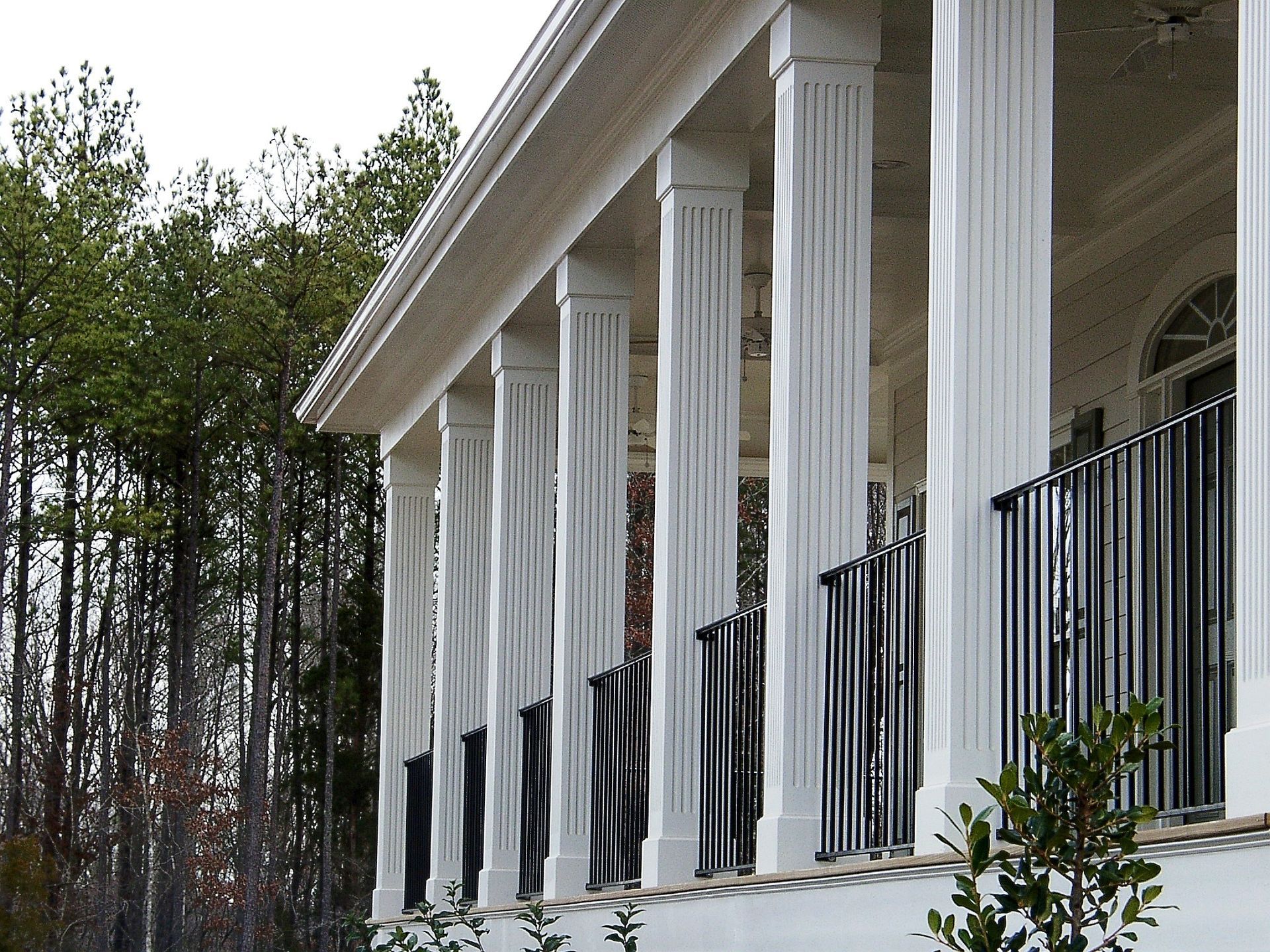 A white building with columns and a black railing