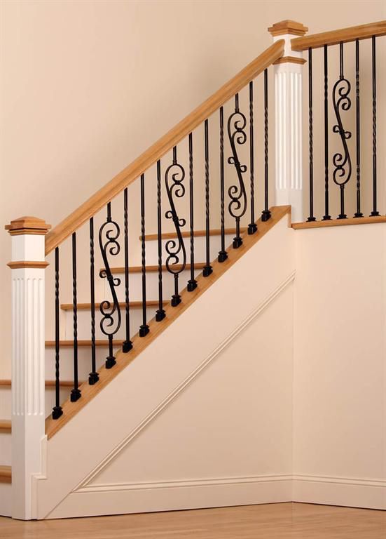 A staircase with a wrought iron railing and a wooden handrail