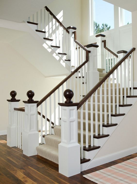 A staircase with white railings and brown handrails