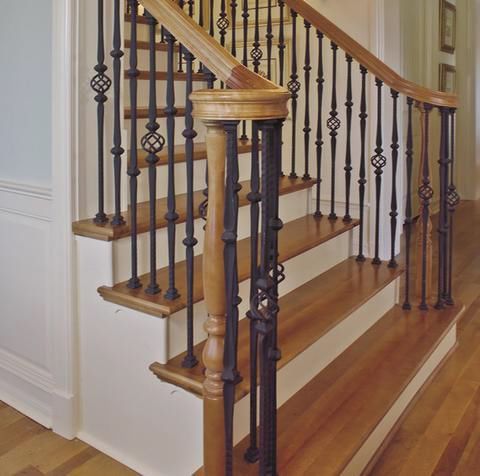 A wooden staircase with a black railing in a hallway