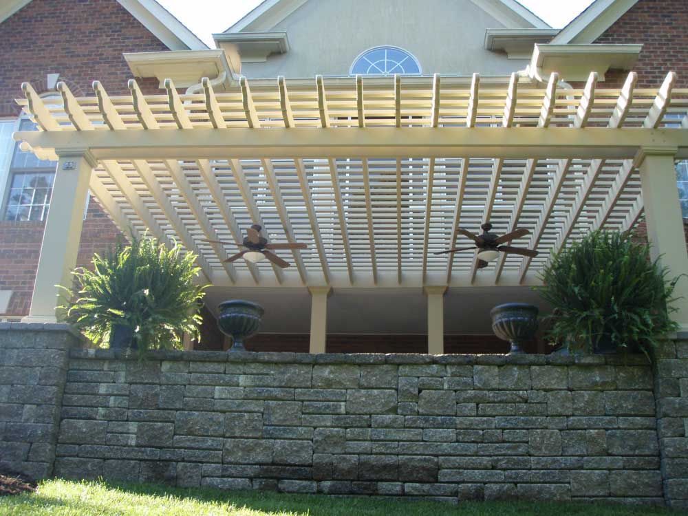 A house with a pergola and ceiling fans on it